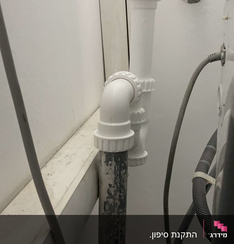 צינורות פלסטיק לבנים מחוברים לקיר